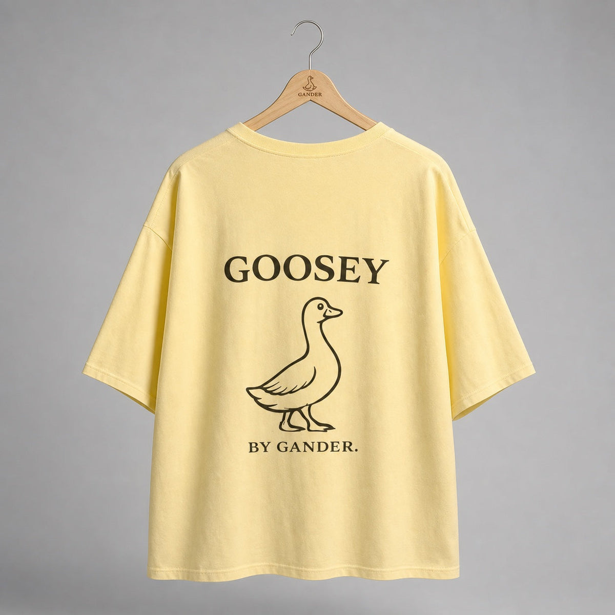 Yellow Gander LTD oversized tee back with Goosey artwork on a Gander wooden hanger